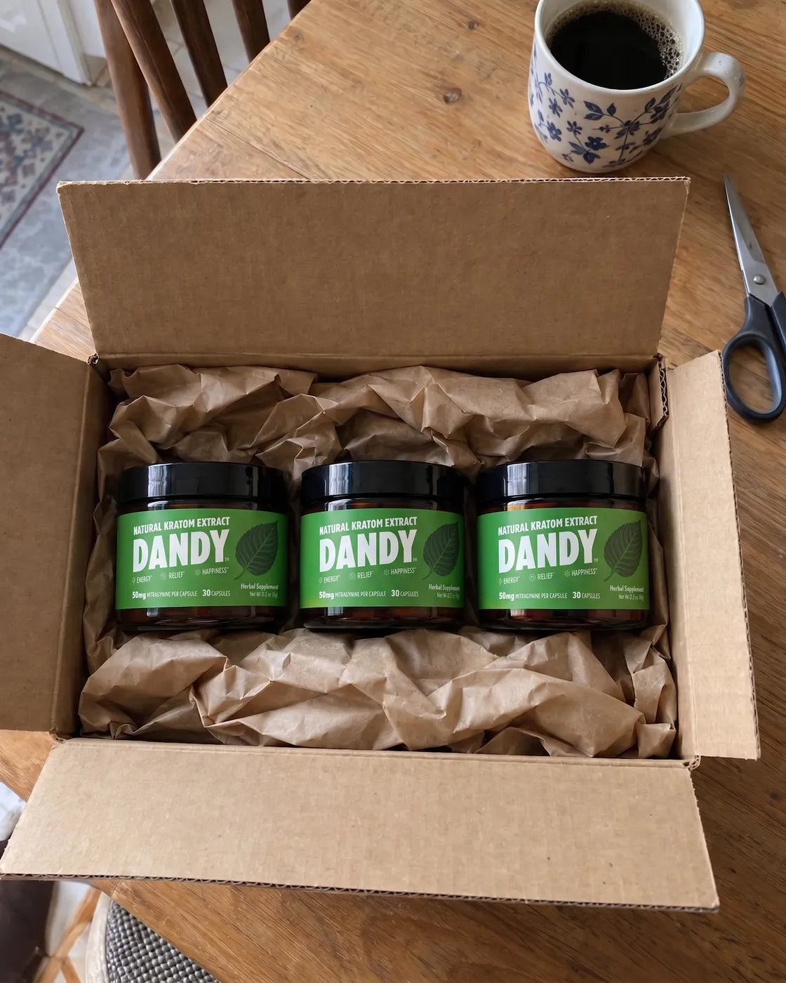 An opened shipping box with three jars of Dandy capsules