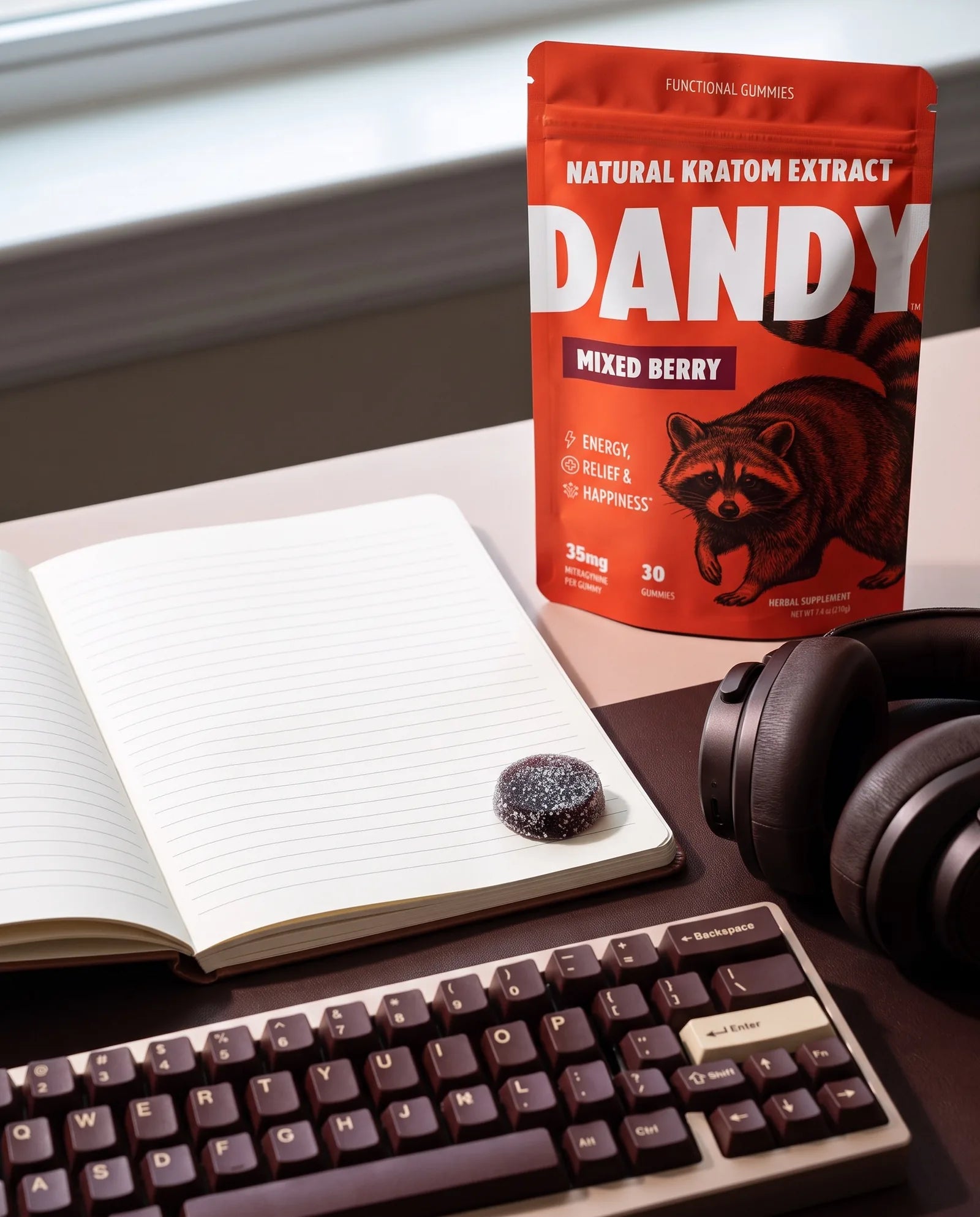 The Dandy Mixed Berry pouch and a gummy on a desk