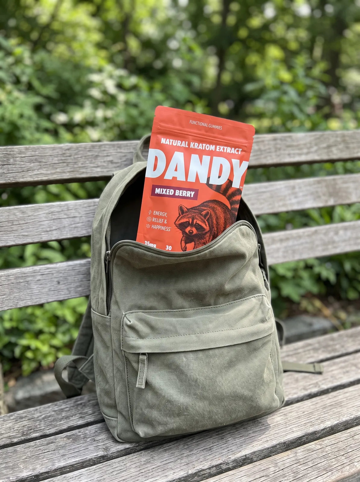 A hand holding one Dandy gummy beside a bag