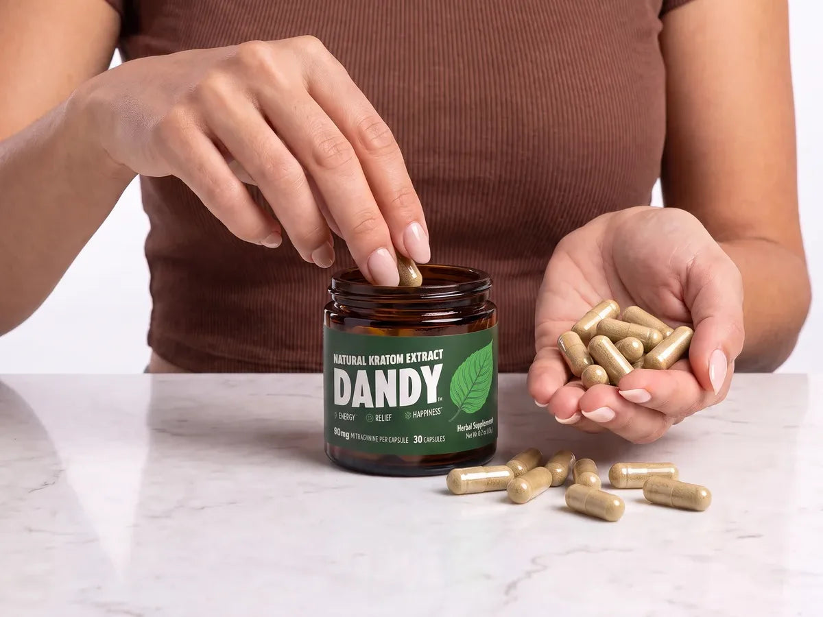 Taking a Dandy extract capsule from the open jar